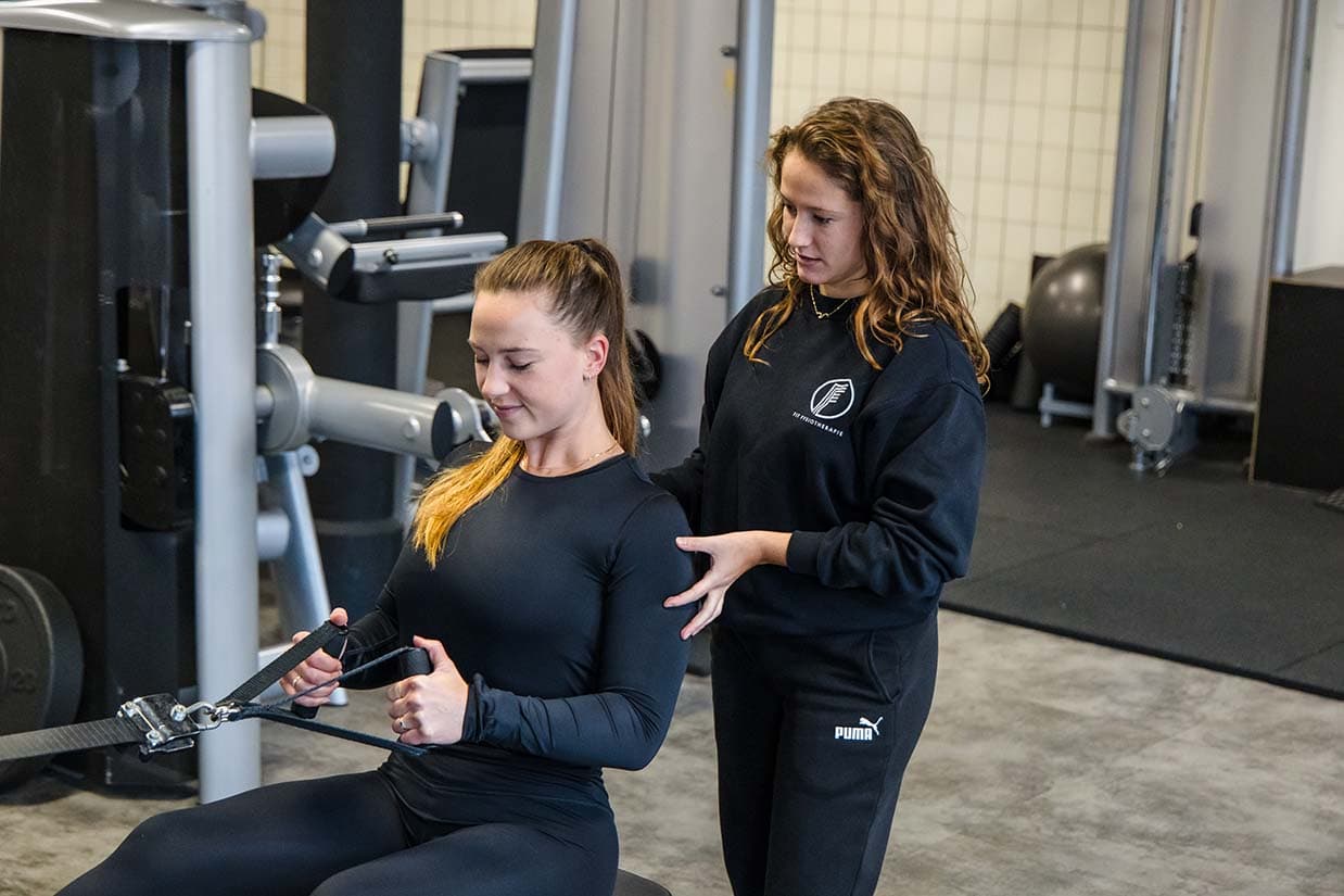 Onze fysiotherapeut helpt bij de uitvoering van een krachtoefening voor de rug.